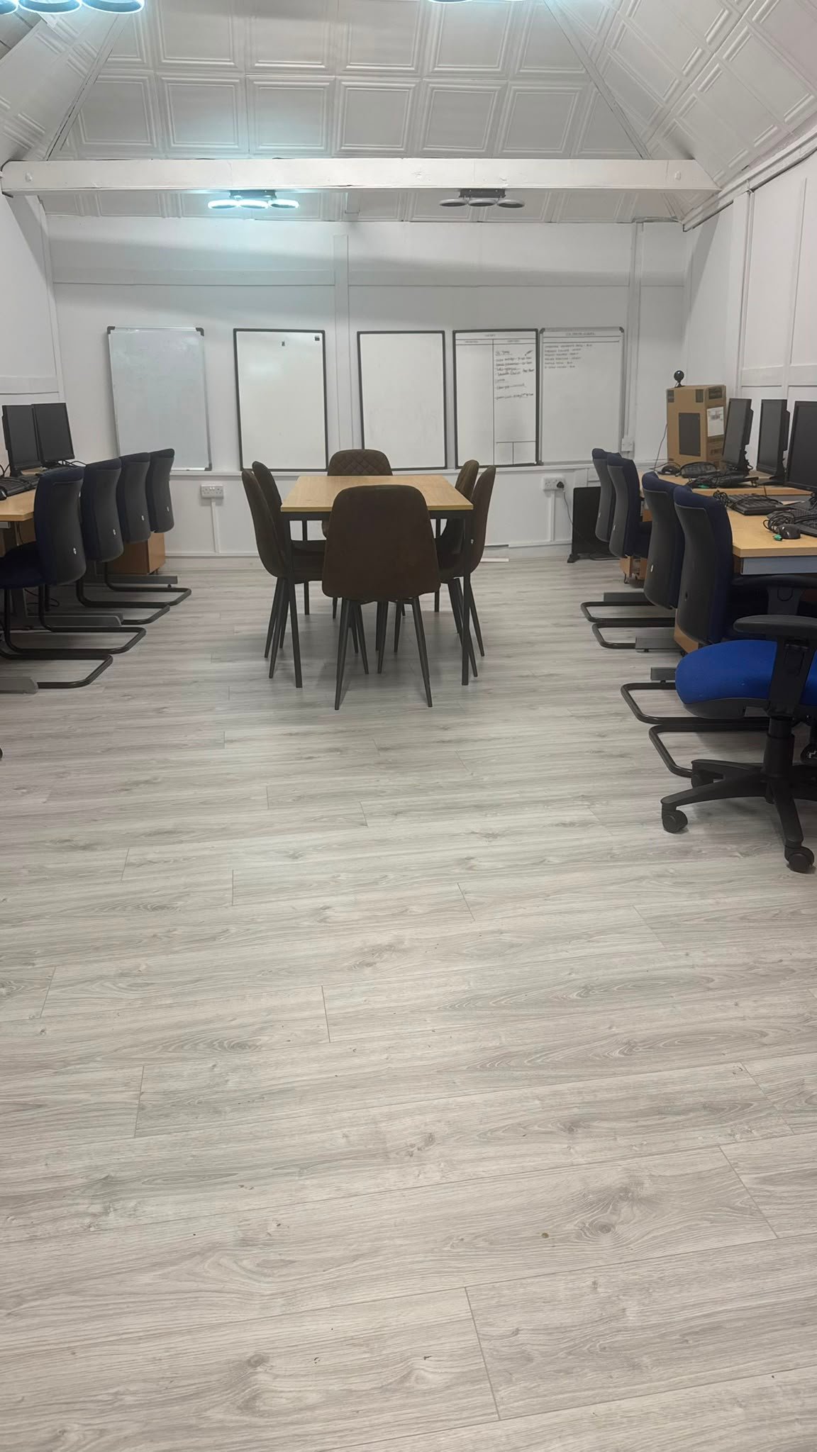 Training and meeting room upstairs at 13 Weeks Café, with a central table, workstations and whiteboards